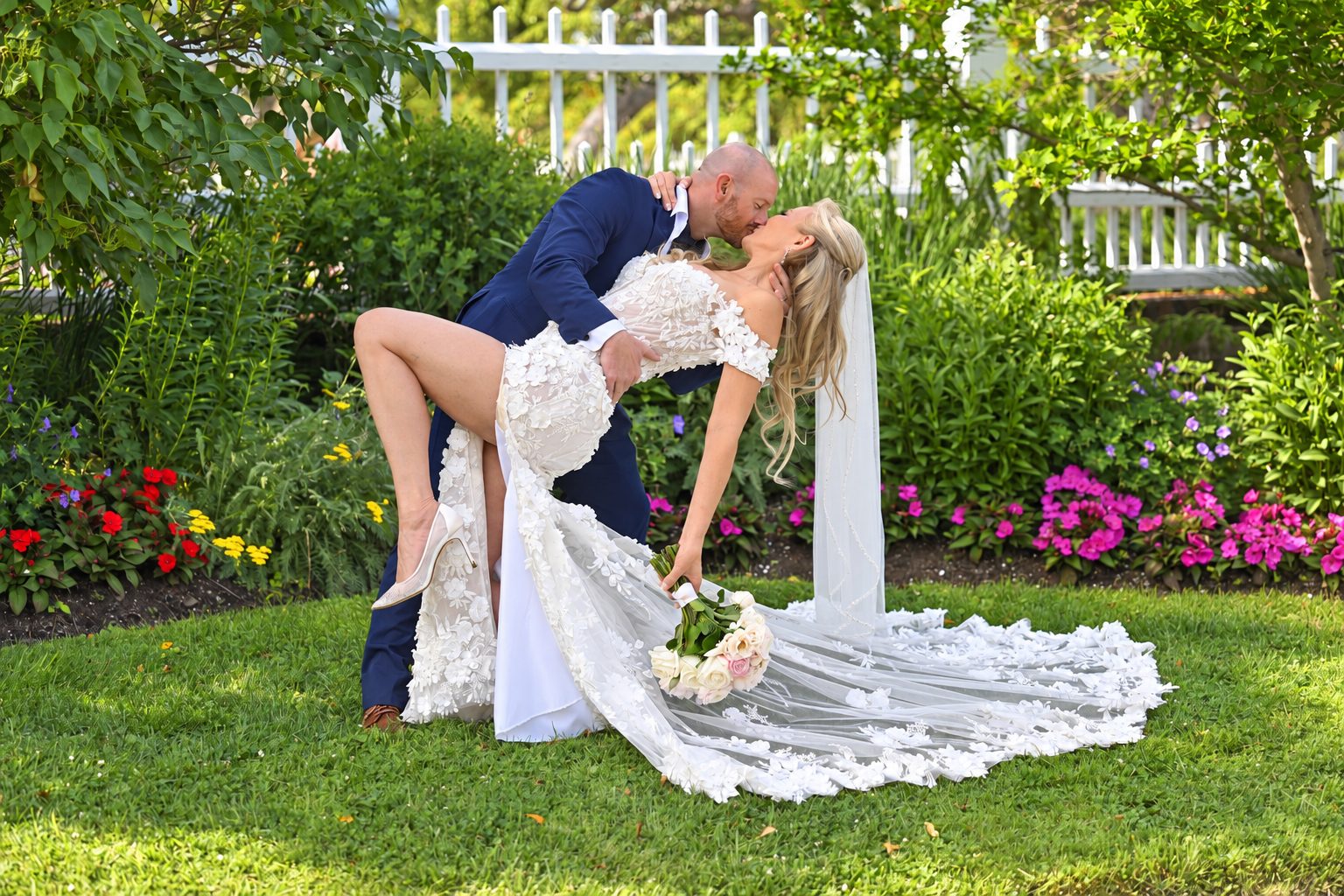 Bride and groom share a kiss in a flower garden