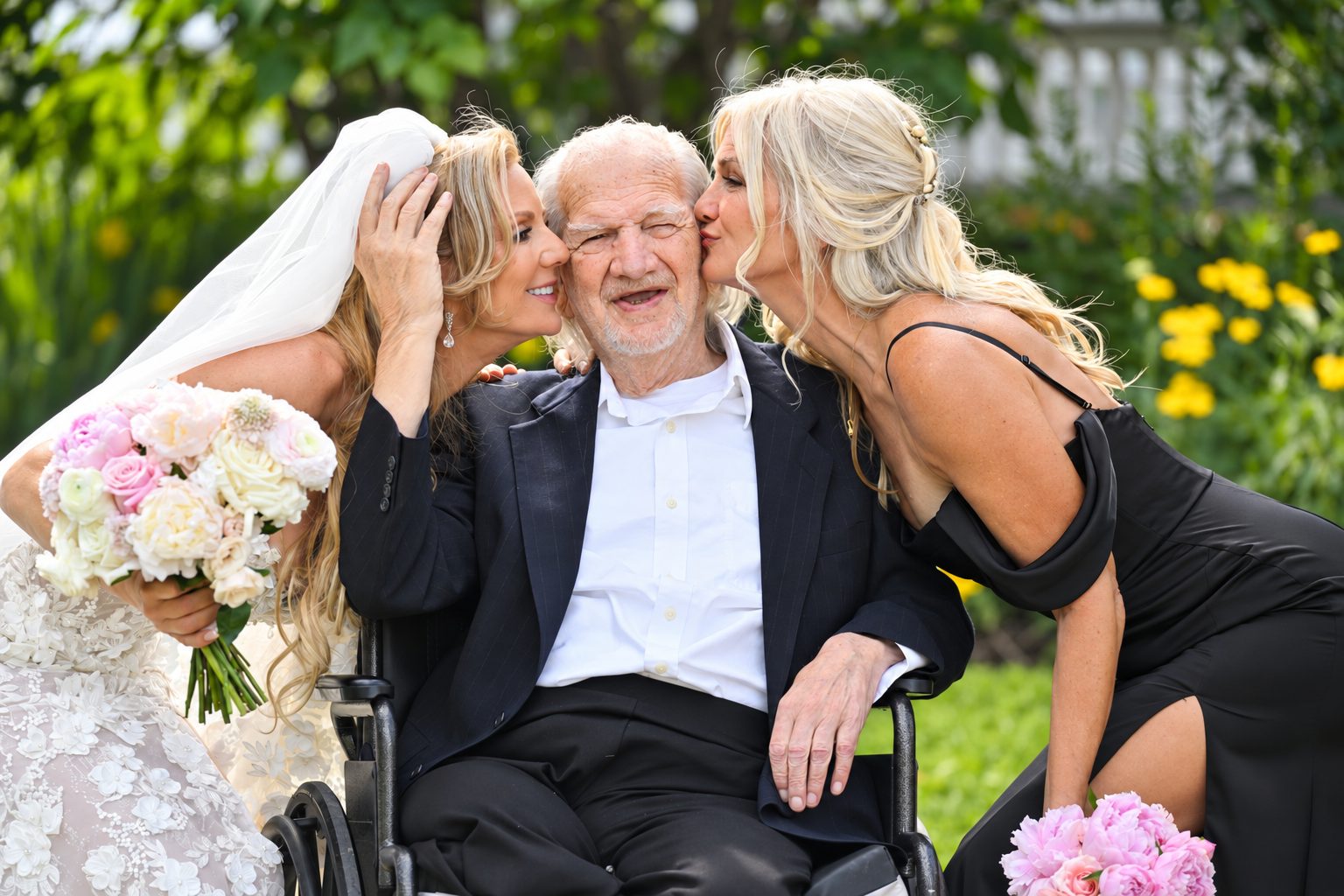 Bride and bridesmaid kiss the bride's grandfather on the cheek
