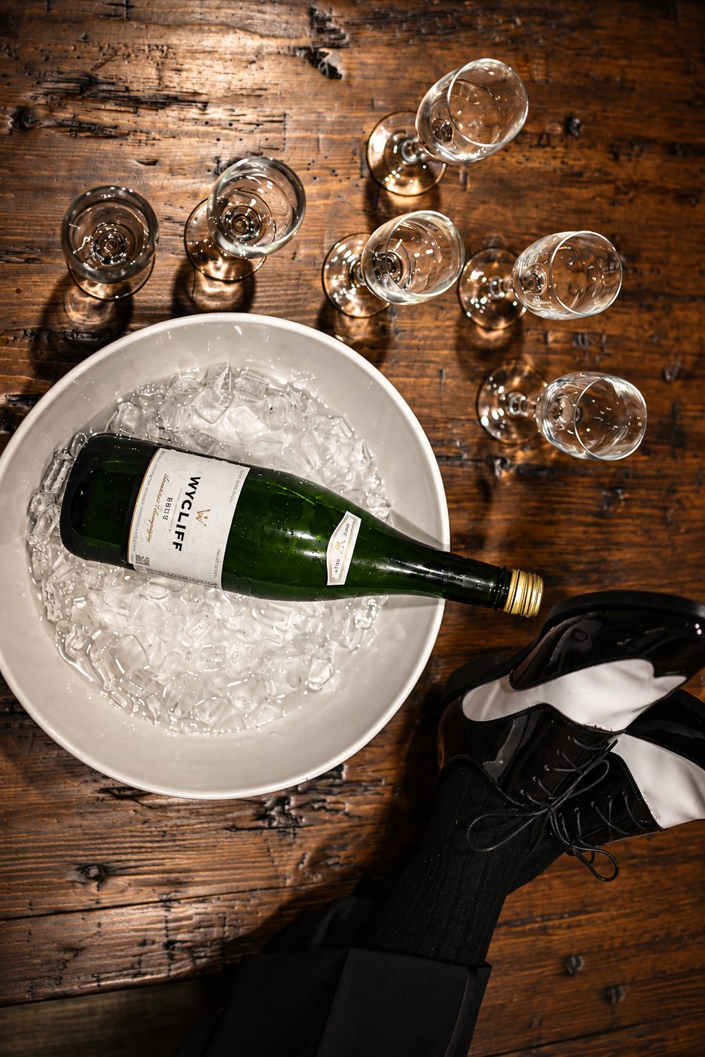 Champagne chilling on ice beside the groom's shoes