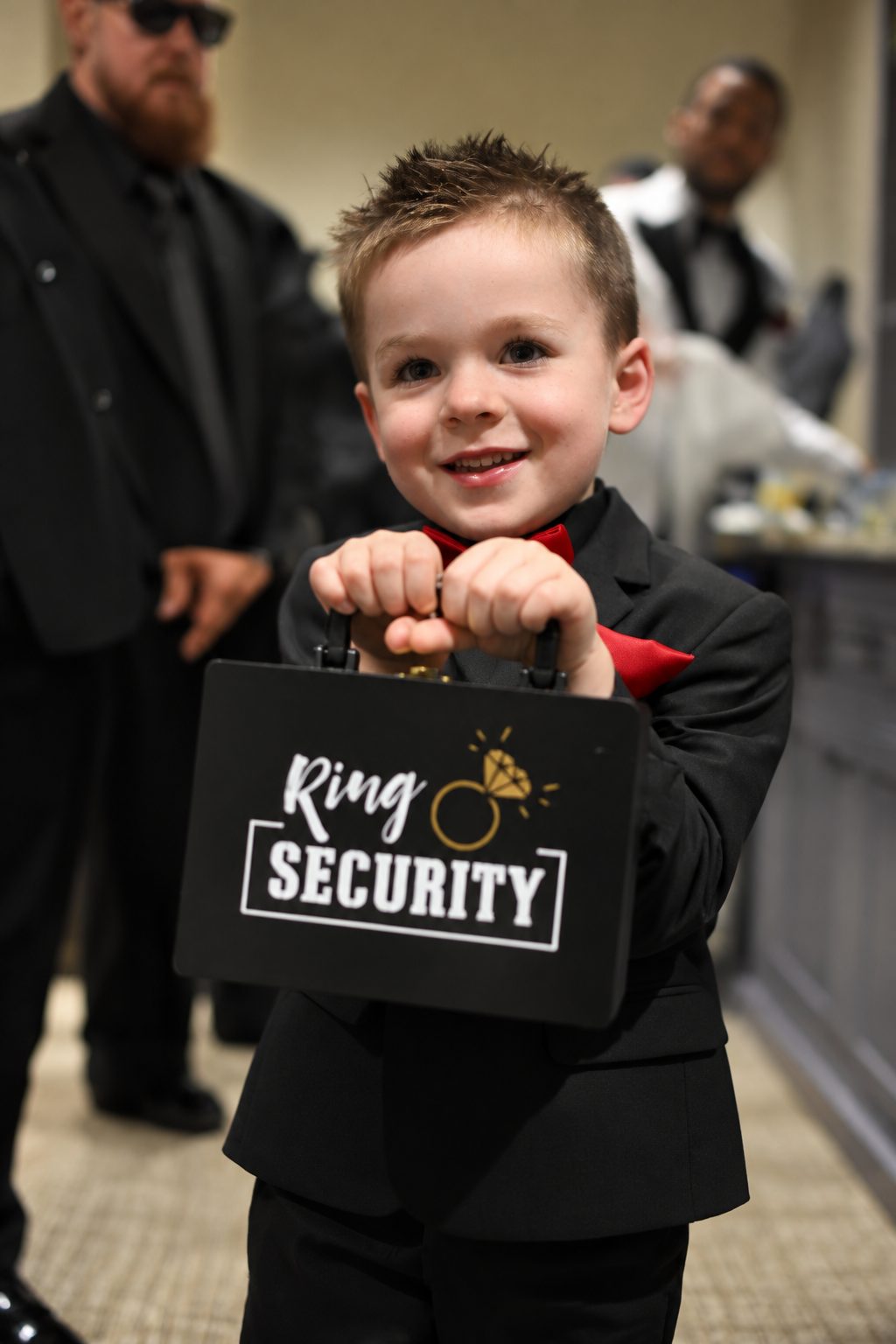 Young ring bearer holding a briefcase labeled Ring Security